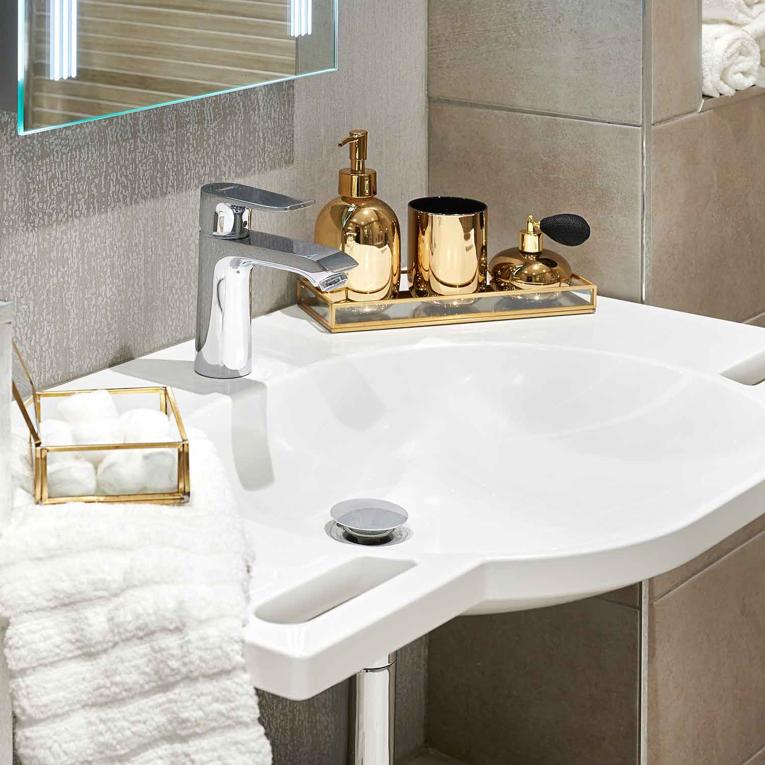 A Fine & Able SurfaceHold washbasin with hand grips and gold accessories on the countertop