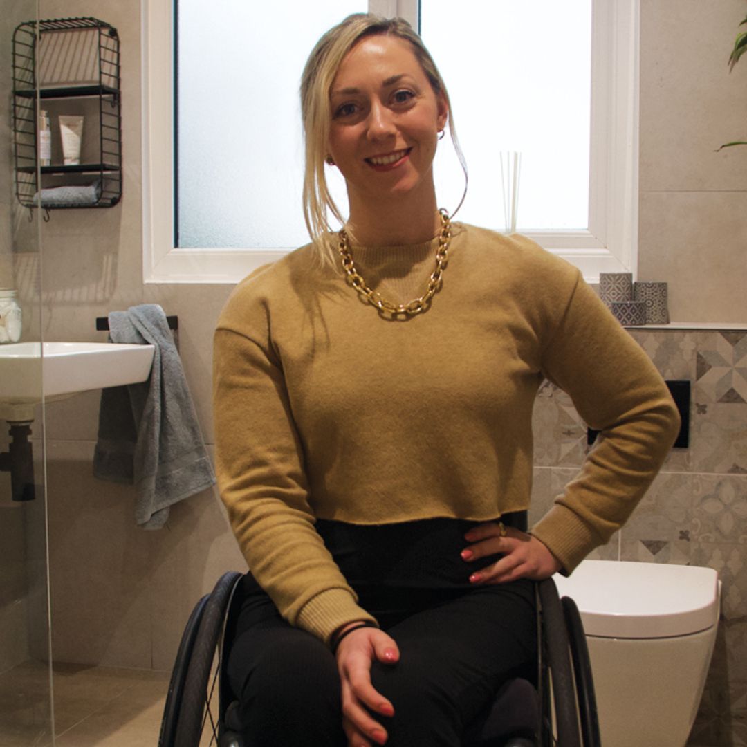 Sophie Carrigill smiling in her new Fine & Able bathroom seated in her wheelchair