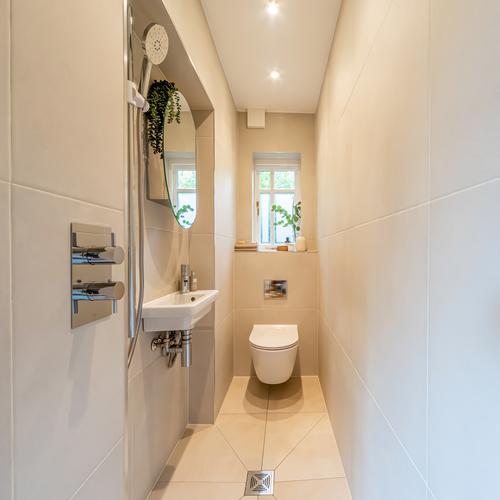 Small neutral accessible tiled cloakroom 